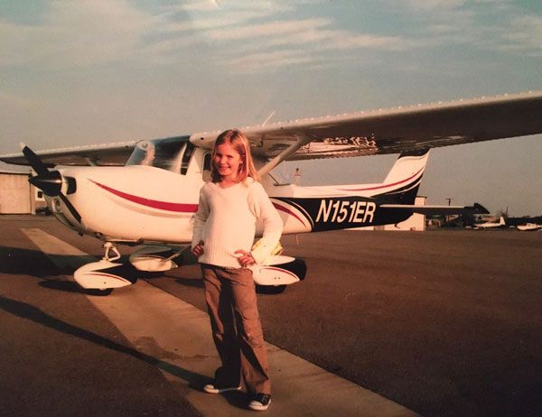 Kelly as a child in front of a plane